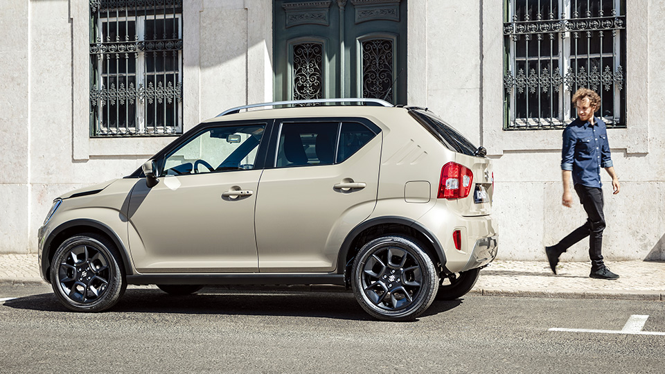 Suzuki Ignis | Kompaktne SUV hübriid | Reklaampilt autost linnahoone taustal.